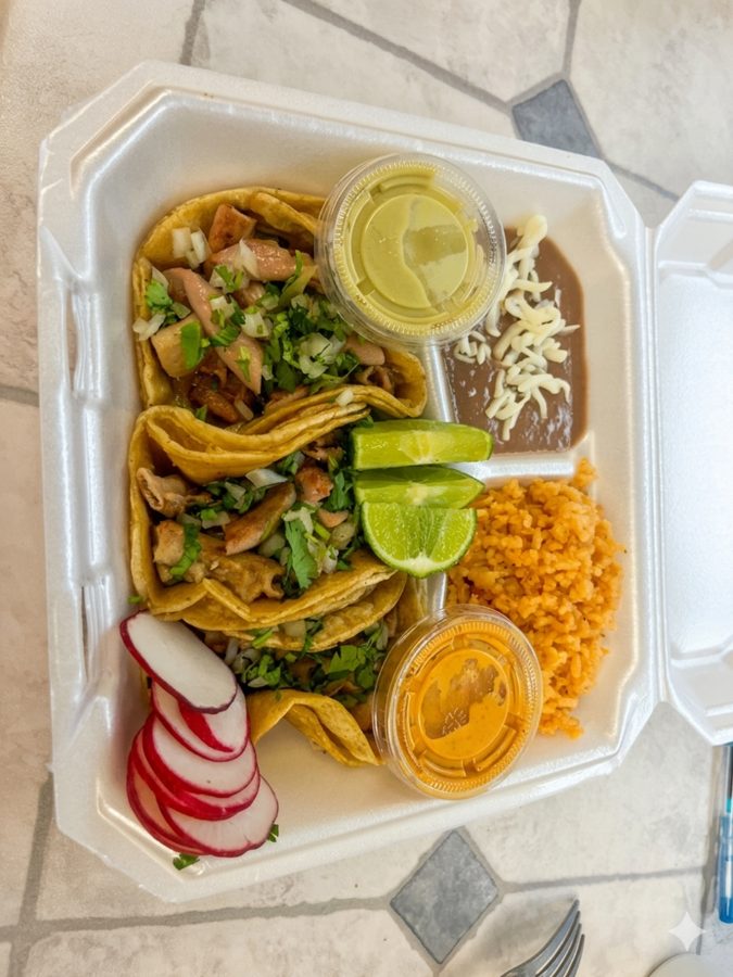 Carry-out box of tacos with rice, beans, salsas and lime